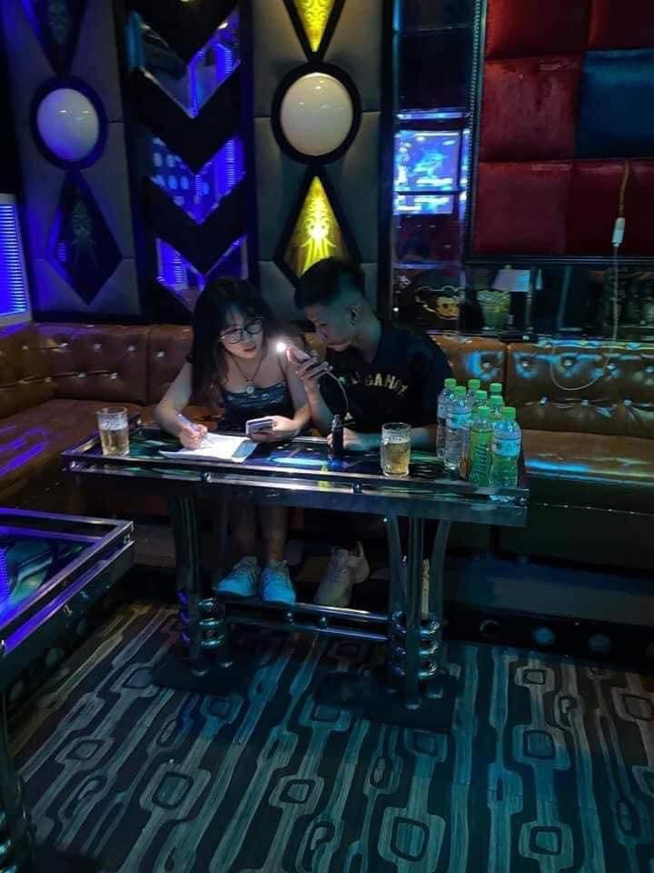 Đôi học sinh nam nữ gái xinh học bài trong quán karaoke